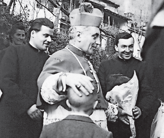 Mons. Angelo Jelmini
negli anni Cinquanta.
Il vescovo è in compagnia del canonico don Arnoldo
Giovannini (a destra nella foto) e di don Guido Marzaro.