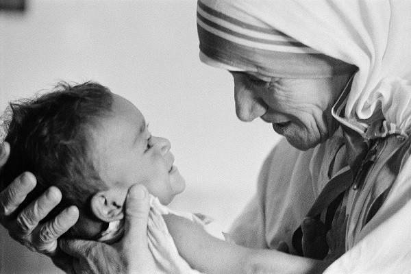 1974, Calcutta, West Bengal, India  --- Mother Teresa with a child from the orphanage she operates in Calcutta. Mother Teresa (Agnes Gonxha Boyaxihu), the Roman Catholic-Albanian nun revered as India's "Saint of the Slums," was awarded the 1979 Nobel Peace Prize.  --- Image by © Nik Wheeler/Sygma/Corbis