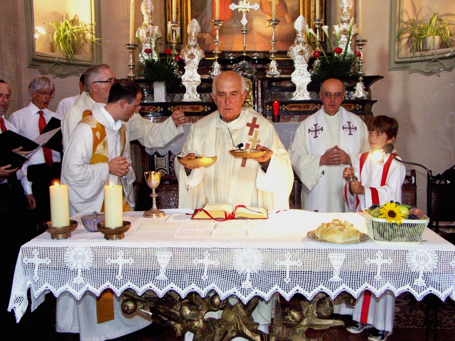 Mons. Vitalini, al centro della foto durante una celebrazione a Neggio