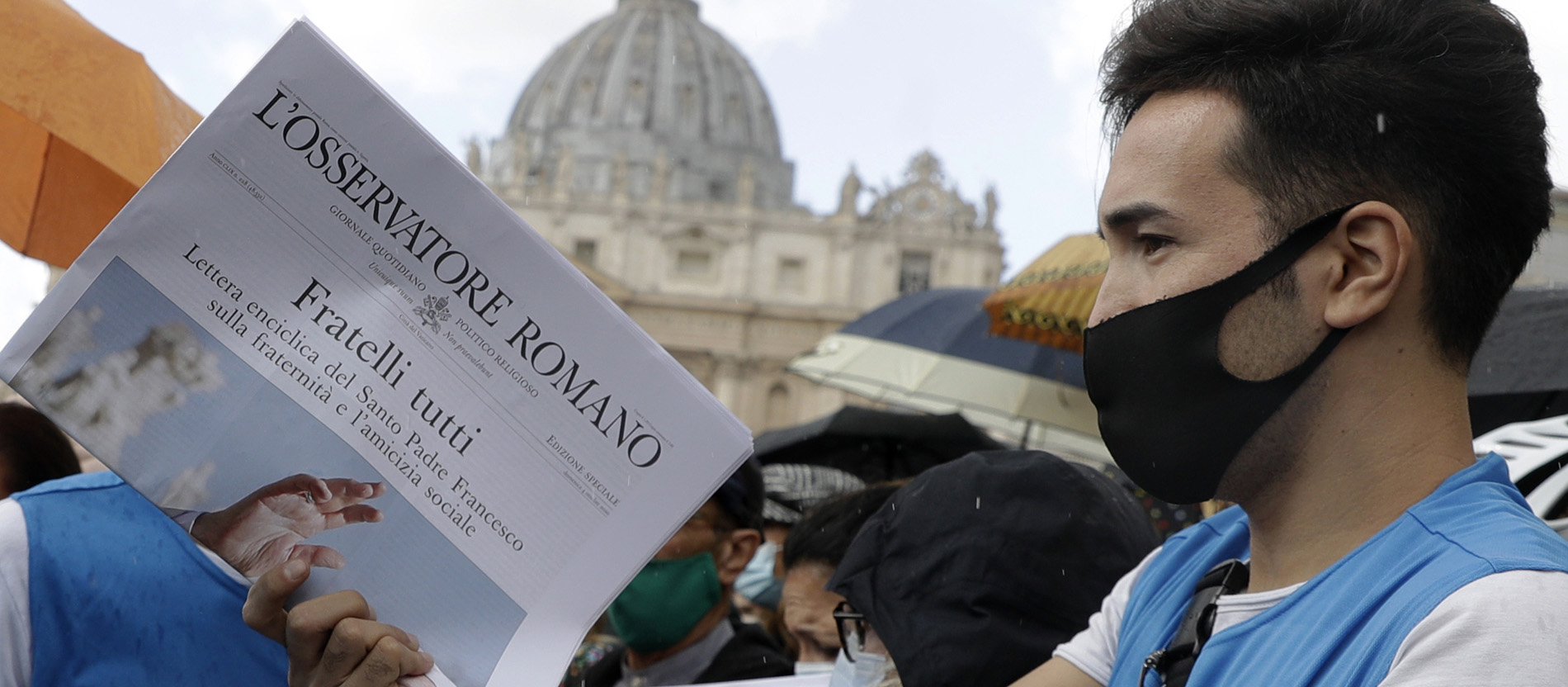 Free copies of the Vatican newspaper L'Osservatore Romano with the front page about Pope Francis' encyclical "All Brothers" are distributed by volunteers to faithful at the end of the Angelus noon prayer in St. Peter's Square at the Vatican, Sunday, Oct. 4, 2020. Francis on Sunday laid out his vision for a post-COVID world by uniting the core elements of his social teachings into a new encyclical, “Fratelli Tutti” (Brothers All), which was released on the feast day of his namesake, the peace-loving St. Francis of Assisi. (AP Photo/Gregorio Borgia)