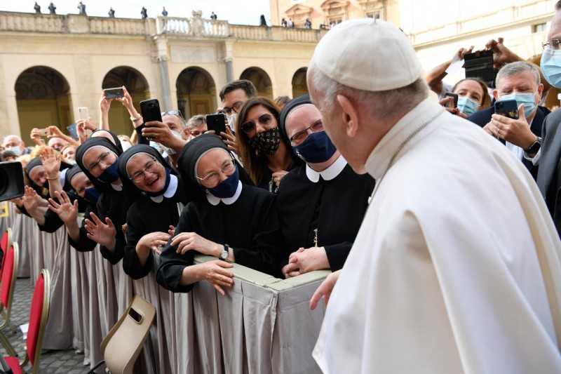 Papa Francesco saluta i fedeli radunati nel cortile di San Damaso per ascoltare la catechesi.