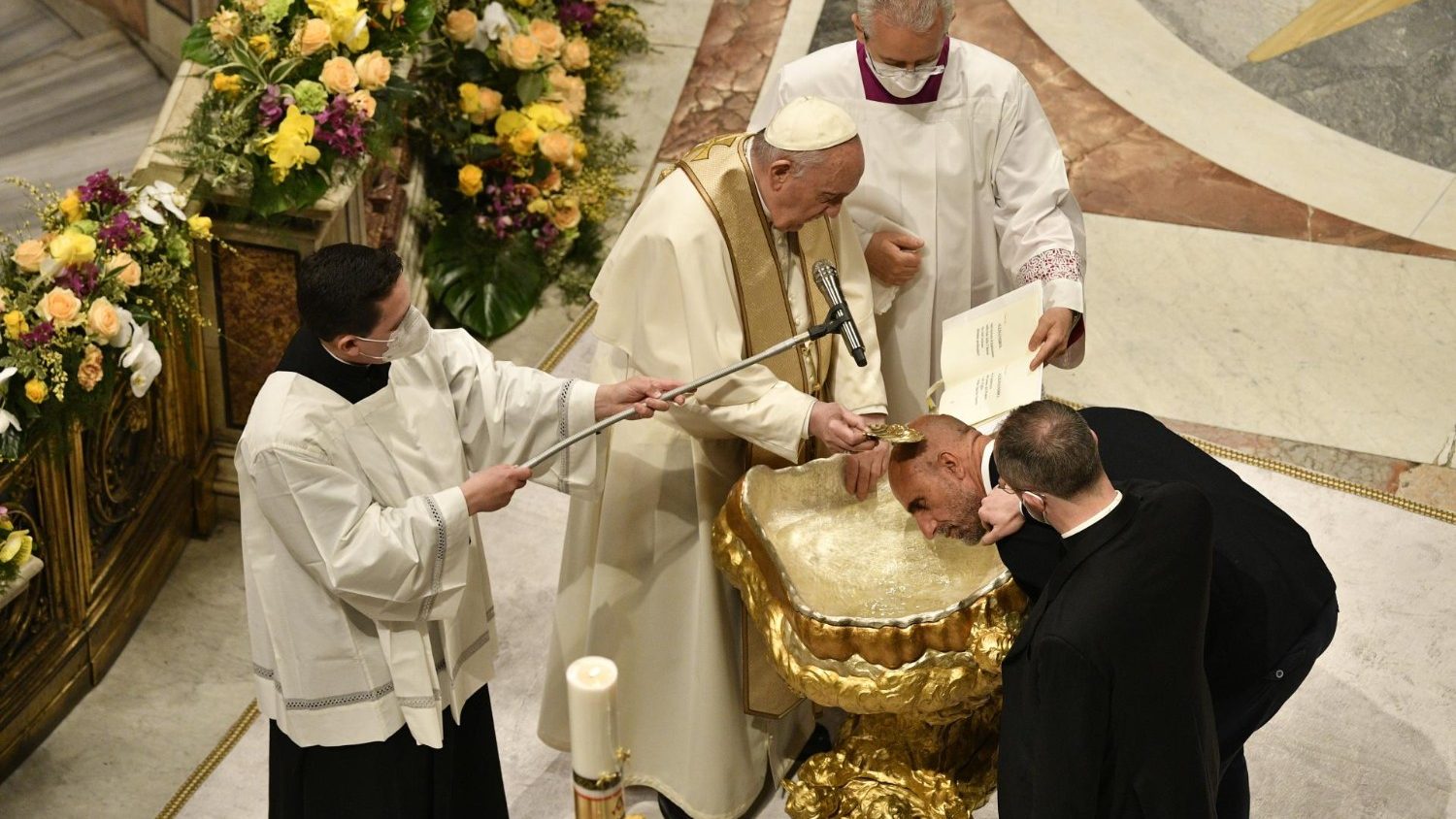 Il Papa mentre amministra un battesimo durante la Vegli pasquale nella basilica di San Pietro